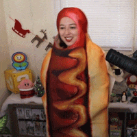 a woman in a hot dog costume is smiling in front of a microphone
