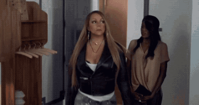 a woman in a black leather jacket is standing next to another woman