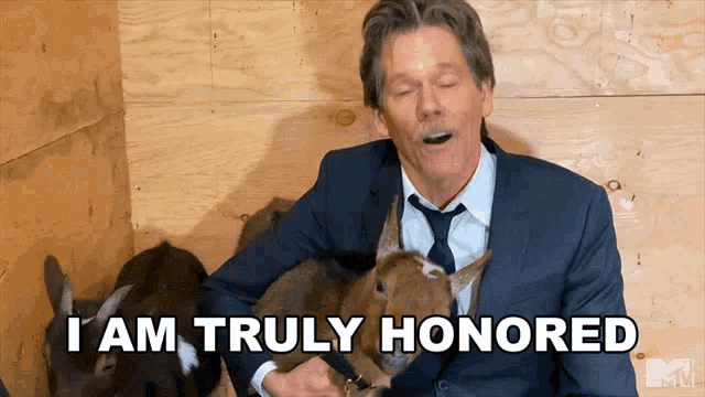 a man in a suit and tie holds a goat and says " i am truly honored "