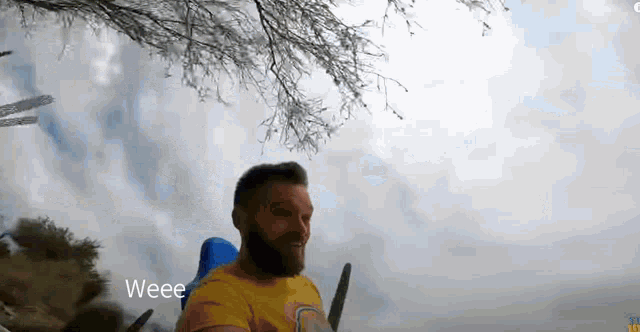 a man with a beard is riding a roller coaster in a park .
