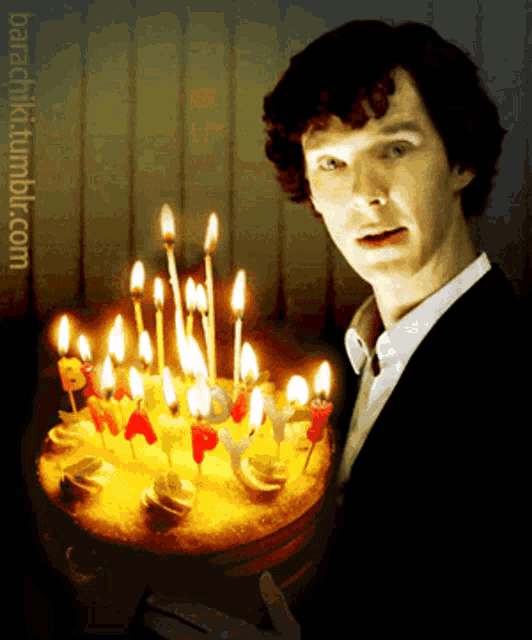 a man stands in front of a birthday cake with lit candles and the words barachi tumblr.com below him