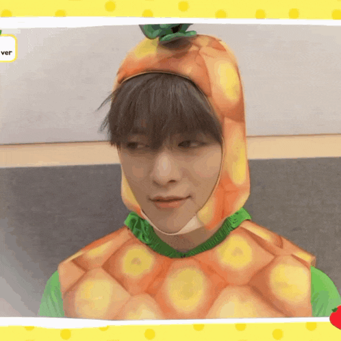 a young man wearing a pineapple costume with a yellow polka dot background