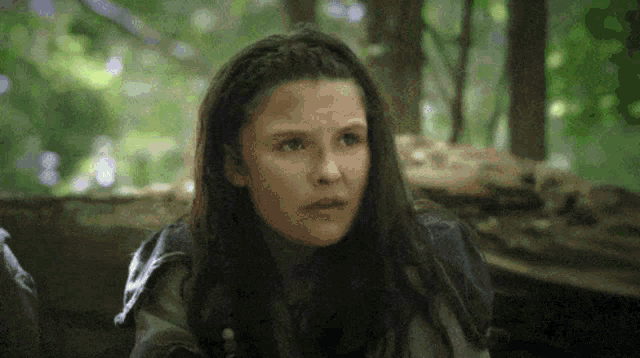 a close up of a girl 's face in the woods