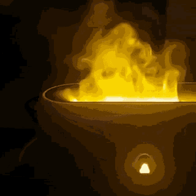 a yellow flame is coming out of a container in the dark