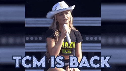 a woman in a cowboy hat singing into a microphone with the words tcm is back behind her
