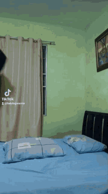 a tiktok video of a person laying on a bed with a picture on the wall