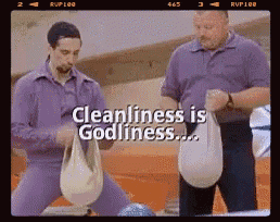 two men are standing next to each other in a bowling alley with the words cleanliness is godliness above them