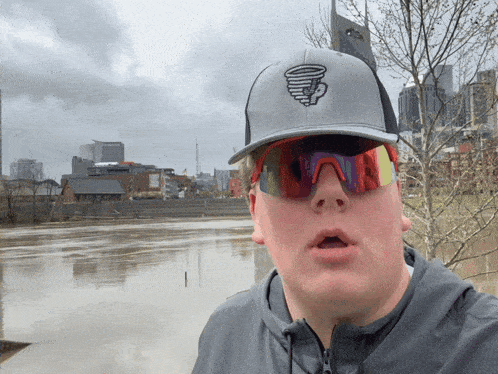 a man wearing a hat with a tornado logo on it