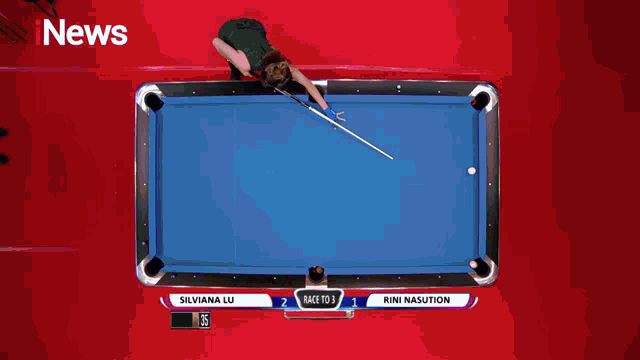 a woman holding a pool cue stands next to another woman in front of a hot pink sign