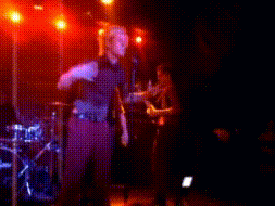 a blurry picture of a man singing into a microphone on stage