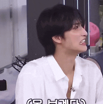 a man in a white shirt is smiling and looking to his left