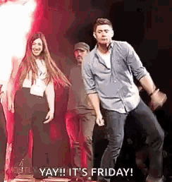 a man and a woman are dancing on a stage in front of a fire .