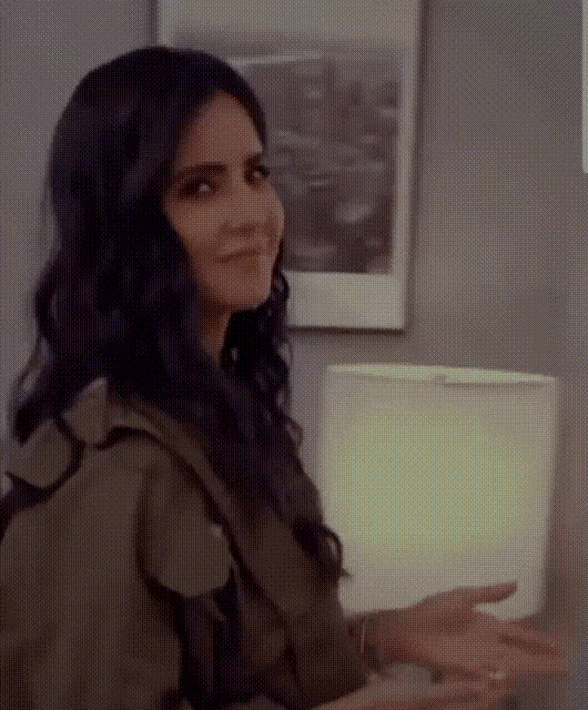 a woman is sitting in front of a lamp in a room .