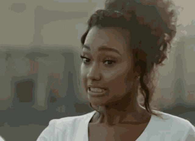 a woman in a white shirt is making a funny face .