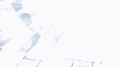 a person is walking on a tiled sidewalk wearing blue sneakers