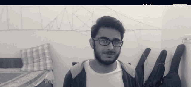 a man with glasses and a beard is standing in front of a wall that says samayal samaya