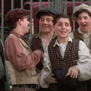 a group of young men are standing next to each other in front of a fence and smiling .
