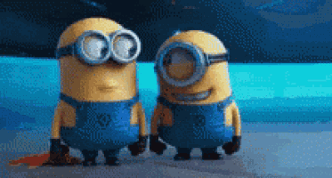 a couple of minions standing next to each other on a beach .