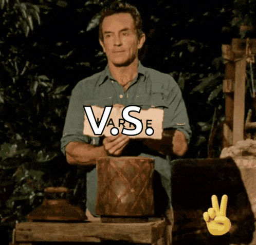 a man is holding a sign that says " vs " on it