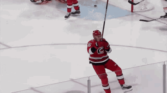 a hockey player wearing a red and black jersey with the letter o on the front