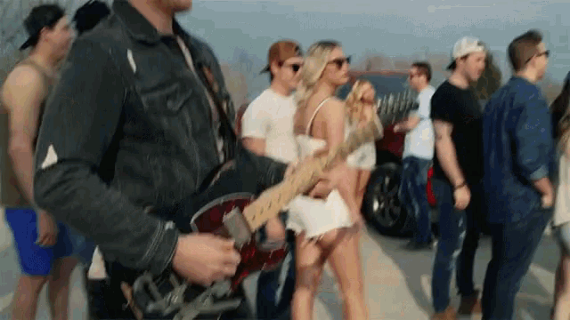 a man playing a guitar in front of a crowd