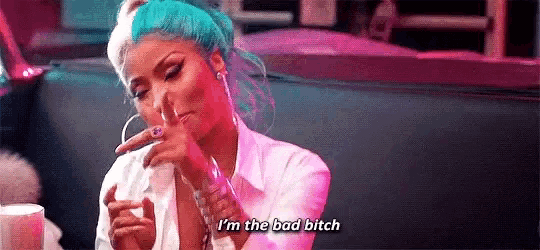 a woman with blue hair is smoking a cigarette and saying `` i 'm the bad bitch ''