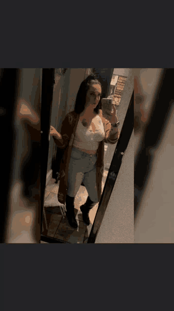 a woman is taking a picture of herself in the mirror