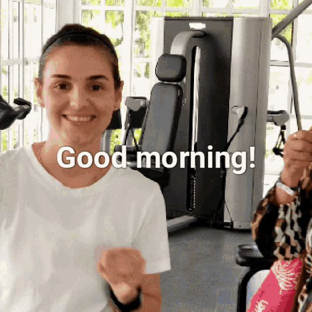 a woman in a gym says good morning in front of a machine