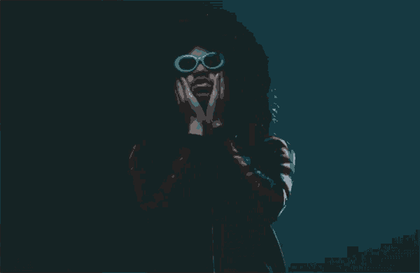 a person with curly hair wearing glasses and a black jacket