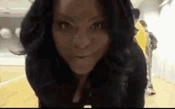 a close up of a woman 's face with a man in the background