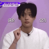 a young man in a white t-shirt is making a funny face while talking into a microphone ..