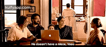 a group of people are sitting around a table with an apple laptop and a woman says he does n't have a niece