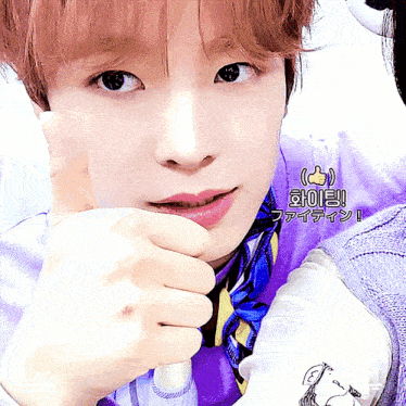 a close up of a person 's face with a purple shirt and a blue tie