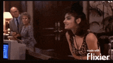 a woman in a leopard print top is sitting at a desk in front of a computer screen that says flixier