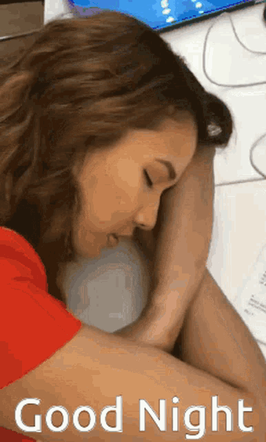 a woman in a red shirt is sleeping on a table with the words good night written below her