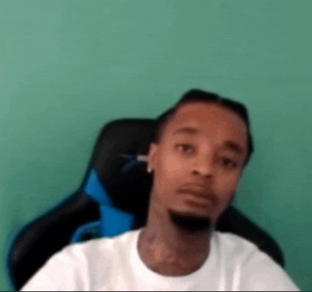 a man is sitting in a chair and making a funny face .