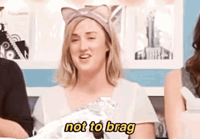 a woman wearing a cat ear headband is saying not to brag