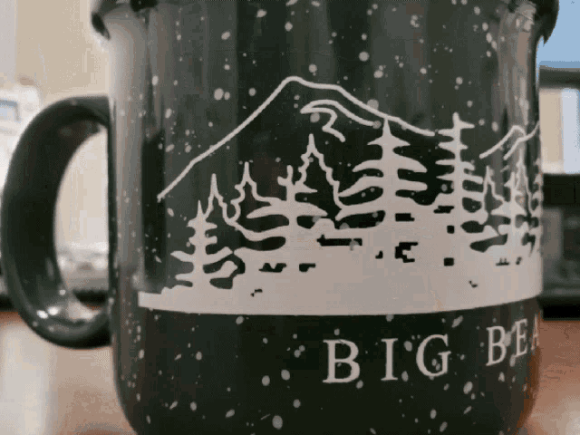 a green mug with a mountain and trees on it that says big bear