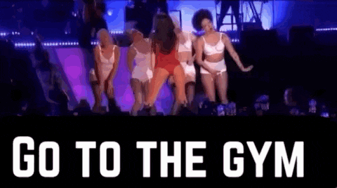 a group of women are dancing on a stage with the words `` go to the gym '' written on the bottom .