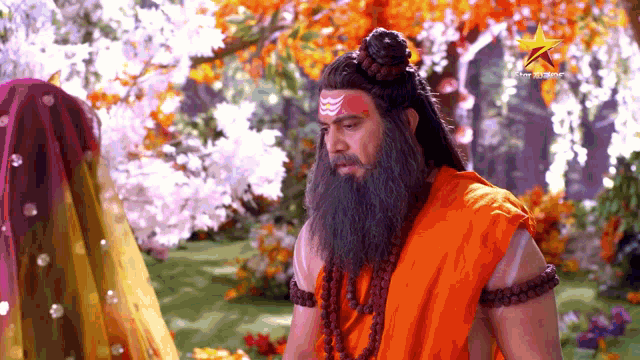 a man with a beard and a red headband is sitting in front of a woman in a yellow dress .