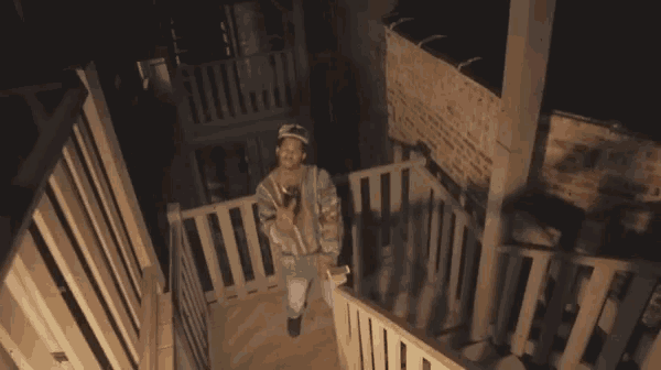 a man walking down a set of stairs with a hat on