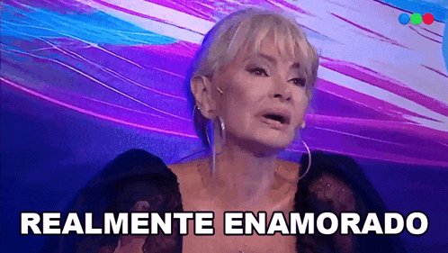 a woman says " realmente enamorado " in front of a colorful background