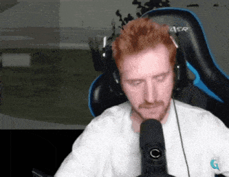 a man with red hair and a beard is wearing headphones and sitting in a chair that says aer on it