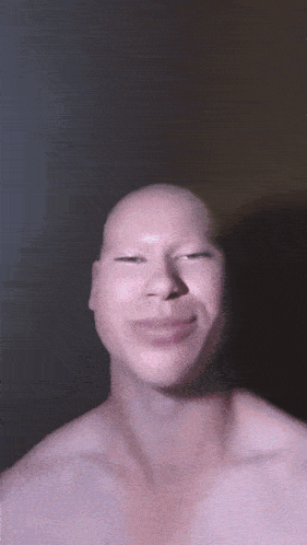a man without a shirt is making a funny face with his eyes closed