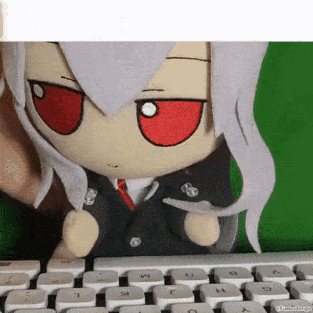 a stuffed toy is sitting on a keyboard with a green background