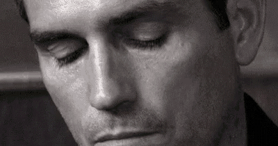 it is a black and white photo of a man with his eyes closed .