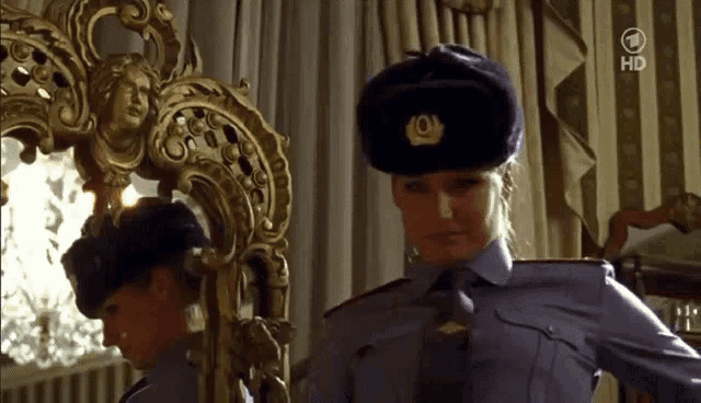 a woman in a police uniform is standing in front of a mirror with the number 1 on the bottom