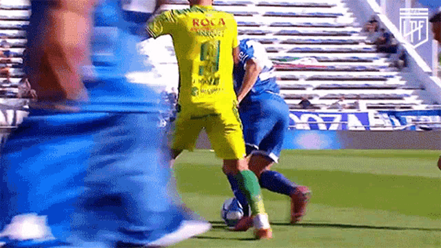 soccer player wearing a yellow jersey that says roca