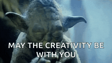 a close up of a statue of yoda with the words `` may the creativity be with you '' written on it .