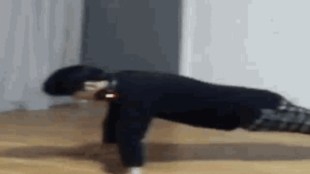 a man is doing push ups on the floor in a room .